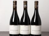 trois bouteilles de vin posées sur une table en bois