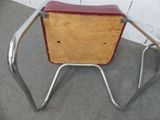 a wooden chair with a metal frame and a red seat