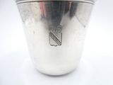 a silver cup sitting on a table with a silver lid