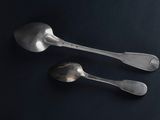 two spoons and a spoon on a black surface