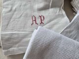 towels with a monogram on them are sitting on a bed