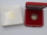 une petite boîte rouge contenant une pièce d'or