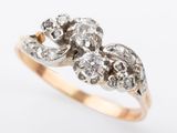 a close up of a gold and diamond ring on a white background