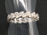 bague en argent ornée d'un motif tressé sur fond noir