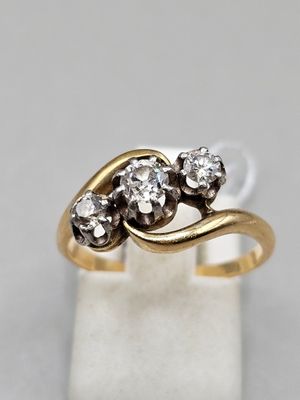gros plan d'une bague en or ornée de trois diamants