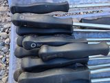 a bunch of knives in a plastic box on the ground