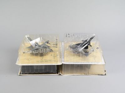 une paire de maquettes d'avions de chasse posées sur un livre ouvert