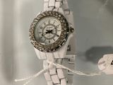 a white watch that is on display in a glass case