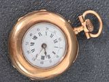 a gold pocket watch with roman numerals on it