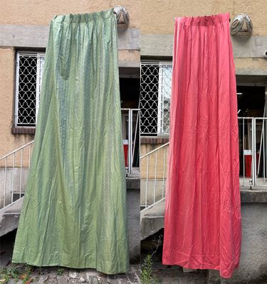 deux rideaux suspendus à une corde à linge à l'extérieur d'un immeuble