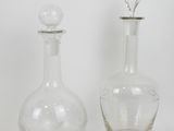 two clear glass bottles with a silver stopper and a clear glass bottle with a silver stopper