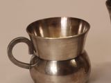 two silver cups sitting next to each other on a table
