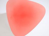 a pink object on a white surface with a white background