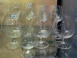 de nombreux verres à vin posés sur une étagère en verre