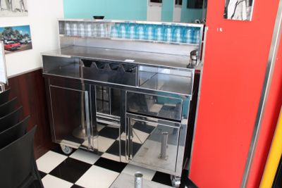 une cuisine avec un sol en damier et un réfrigérateur rouge