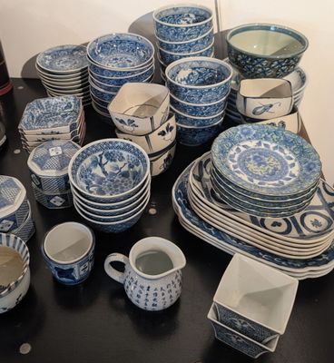 de nombreuses assiettes et tasses bleues et blanches sur la table