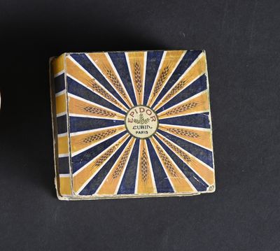 two small boxes with decorative designs on them sitting on a black surface