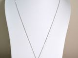 yellow and white necklace on a white mannequin with a gold and silver pendant
