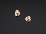 a pair of gold and diamond earrings on a black background