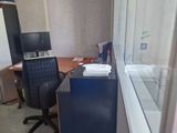 a desk with a computer and a chair in a room