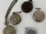 four different types of pocket watches on a white surface