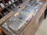 a counter with a variety of trays of food on it