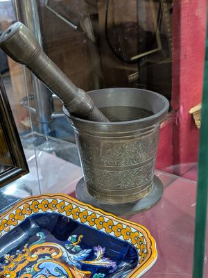 une vitrine en verre sur laquelle sont posés un bol et un pinceau à mortier
