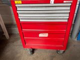 a close up of a red tool box on wheels in a garage