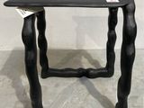 une petite table en bois noir sur laquelle est posée une étiquette