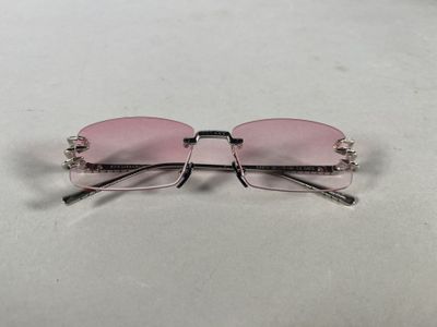 a pair of pink sunglasses sitting on top of a white surface
