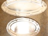 two silver trays sitting on a counter top