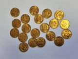 a pile of gold coins sitting on top of a white surface