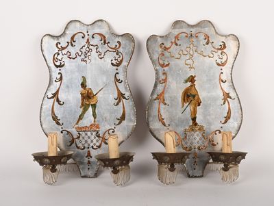 two wall sconces with a painting of a man and a woman on them