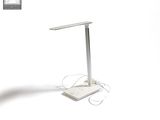 une photo d'une lampe de bureau posée sur une surface blanche