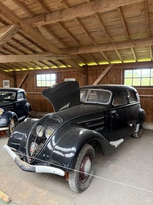 deux vieilles voitures garées dans un garage, le capot ouvert