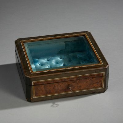 a small box with a glass inside of it on a table