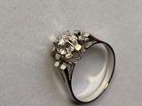 une image d'une bague en diamant sur une surface blanche