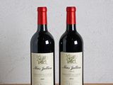 deux bouteilles de vin posées sur une table en bois, à côté d'une bouteille de vin