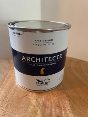 un pot de peinture posé sur une table en bois