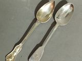 two spoons that are sitting next to each other on a table