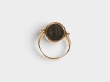 a close up of a gold ring with a black stone on it
