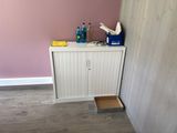 a white cabinet with a drawer in the corner of a room