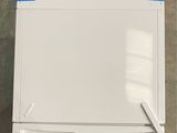 an overhead view of a white refrigerator with blue tape on the door