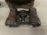 an old pair of binoculars sitting on top of a table next to a bag