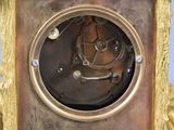 a gold clock with a clock face in the middle of it