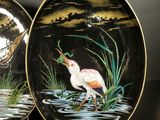 two plates with birds painted on them on a table