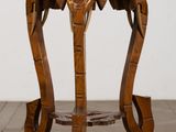 une table en bois sur laquelle est sculptée une tête d'éléphant
