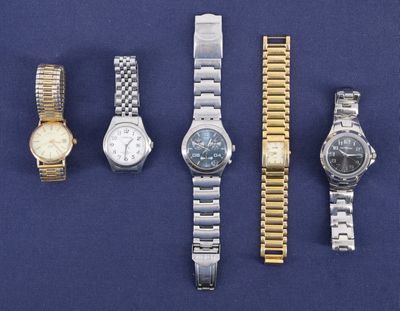 Plusieurs montres sont alignées les unes à côté des autres sur une surface bleue