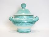 a blue and white bowl with a lid on a white surface