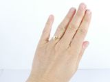 la main d'une femme à laquelle est passée une bague en or